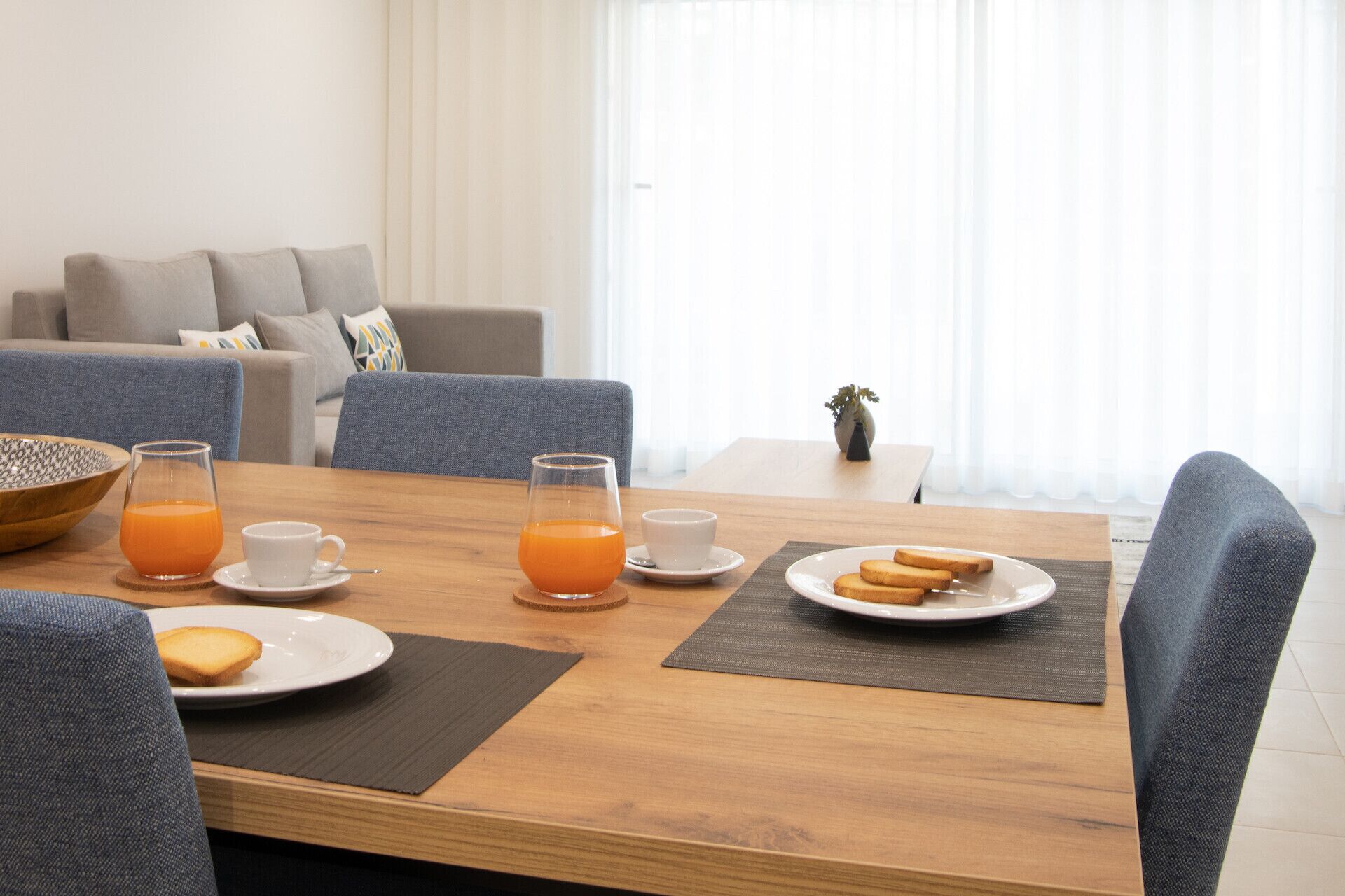 Una mesa de comedor con alimentos para el desayuno, un tazón y un florero.