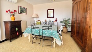 A dining area with a table set for four, a radiator, a lamp, and a wooden cabinet.