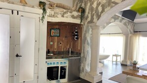 Cozinha com bancada de madeira, resfriador de vinhos embutido e um aviso que diz 'FESTA DA CERVEJA'.