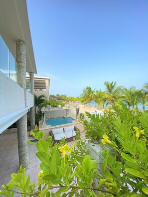 A pool area with a hot tub, lounge chairs, and a view of the beach. - Casa de Playa Villa Ruben (Guayacanes)