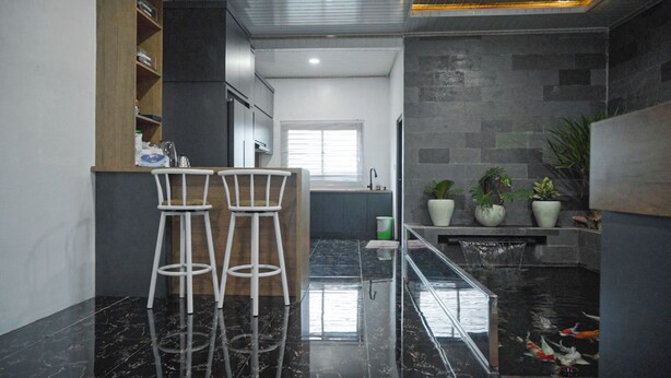Una cocina moderna con dos taburetes blancos, una estufa empotrada y un lavamanos pequeño.
