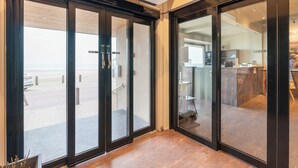 A modern interior with sliding glass doors leading to a patio area. - Studio in Blankenberge Near the Beach (Blankenberge)