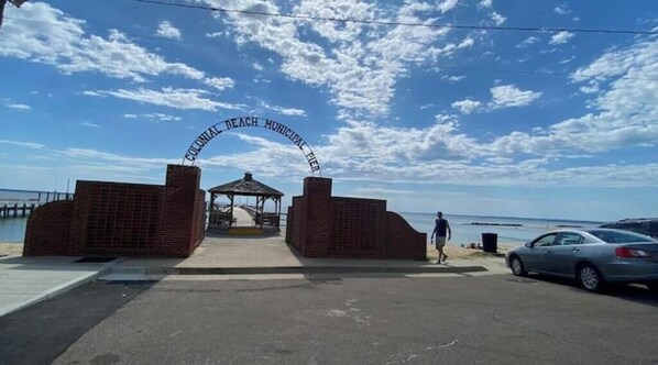 A beach entrance with a sign reading "Colonial Beach Municipal Pier".