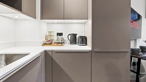 Et moderne køkken med indbyggede skabe, en vask og en kaffemaskine.
