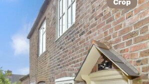 A brick house with a white door, a small garden, and a clear sky. - Arundel Cottage Retreat (Arundel)