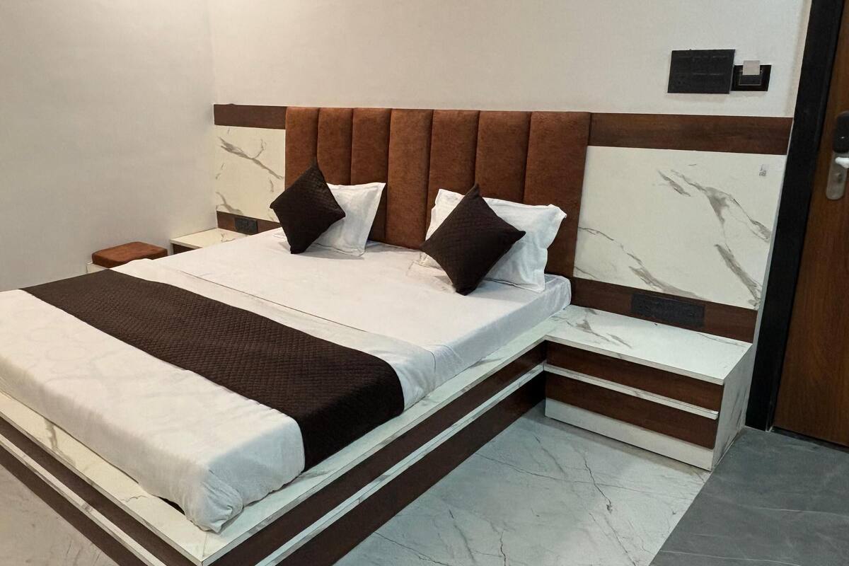 A modern bedroom with a large bed, a nightstand, and a marble-patterned headboard.