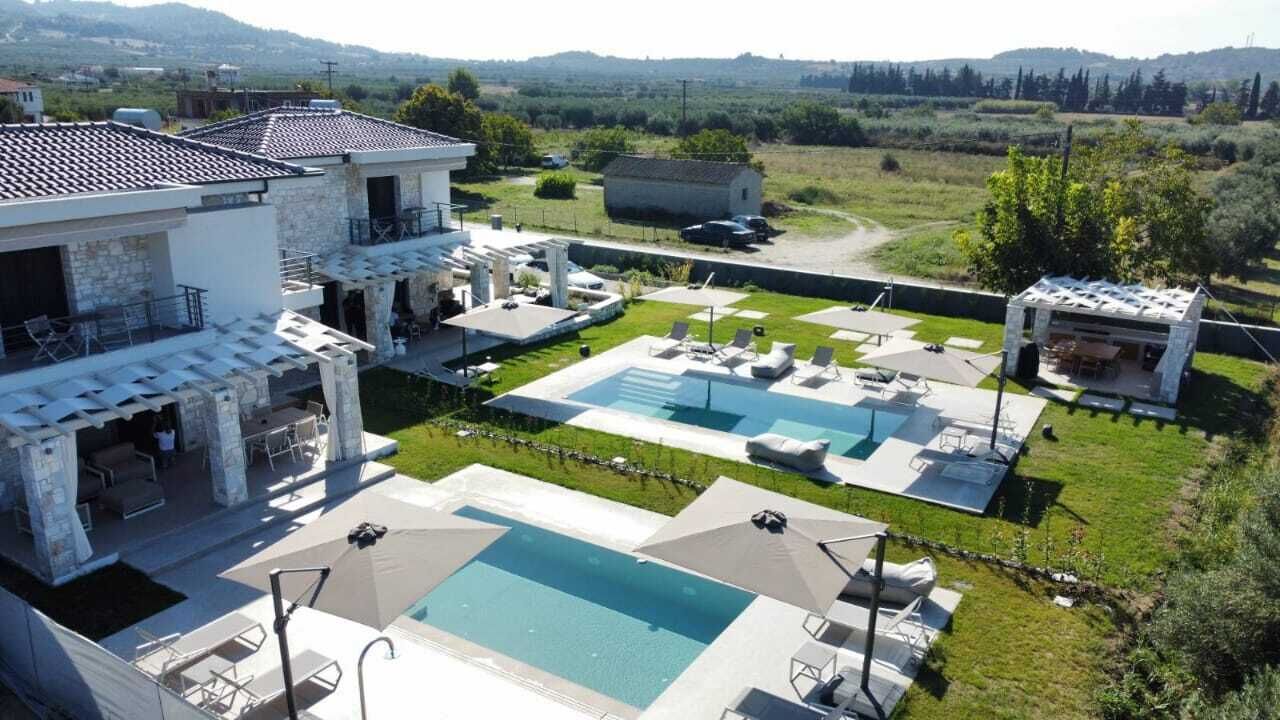 Une villa moderne dotée d’une piscine, d’un espace extérieur aménagé et offrant une vue sur la campagne.