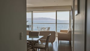 Et moderne værelse med en stor skydedør, der fører ud til en balkon med hav- og bjergudsigt.