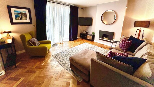 Un salon avec un canapé, un fauteuil et une cheminée.