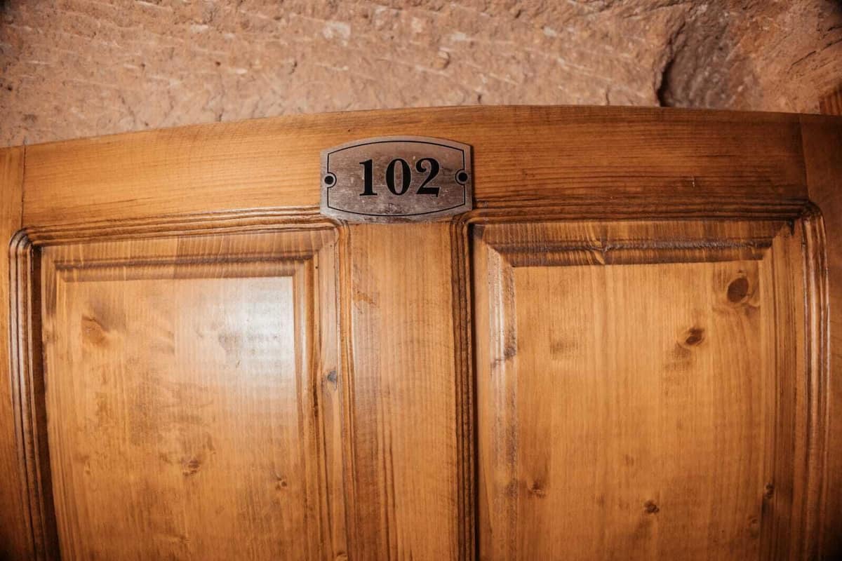 Classic door with a brass plaque and central handle, set in a traditional stone or concrete area.