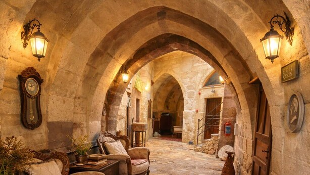 An arched stone corridor with antique furniture and a red carpet. - 7 Oda Kapadokya Cave House (Urgup)