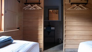 A wooden room with two beds, a small bathroom, and wooden walls. - Escape to Nature in Vencimont (Gedinne)