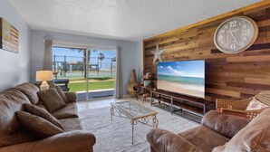 Una sala de estar con un televisor grande, sofás de cuero, una pared de madera y una decoración con motivos de estrellas.