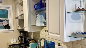 Eine Küche mit Granit-Arbeitsplatten, weißen Schränken, einer Edelstahl-Spüle und einem Toaster.