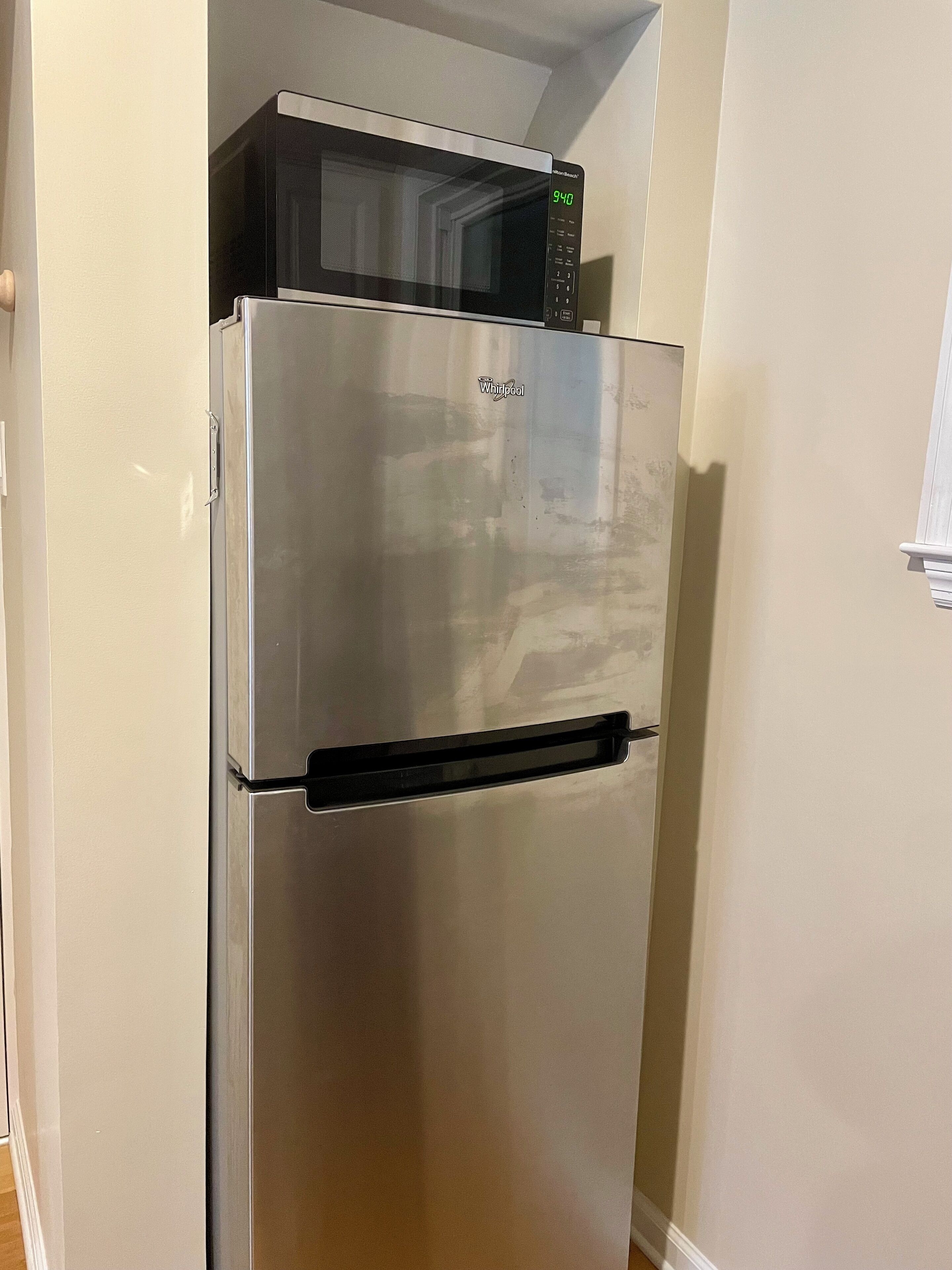A stainless steel Whirlpool refrigerator with a digital display and a freezer compartment.