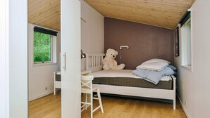 A bedroom with a bed, a chair, a window, and a teddy bear. - 8 Person Holiday Home in Holbaek (Holbaek)
