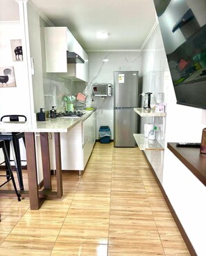 コンフォート アパートメント | 専用キッチン | 大型冷蔵庫、電子レンジ、コンロ、調理器具と食器