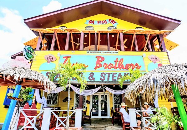 Un edificio colorido con un letrero que dice "DA FISH FRY" y "Brothers & Steaks".