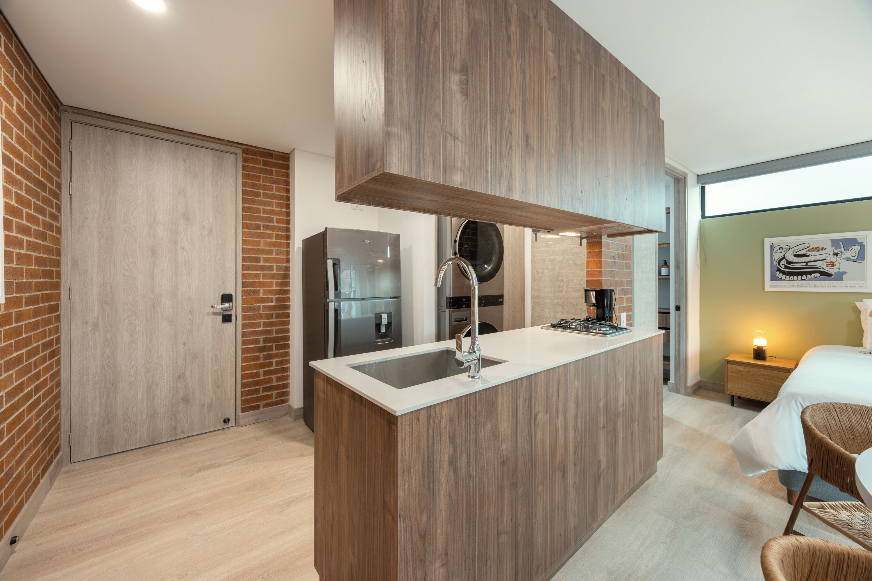 A modern kitchen with a built-in island, stainless steel appliances, and a brick accent wall.