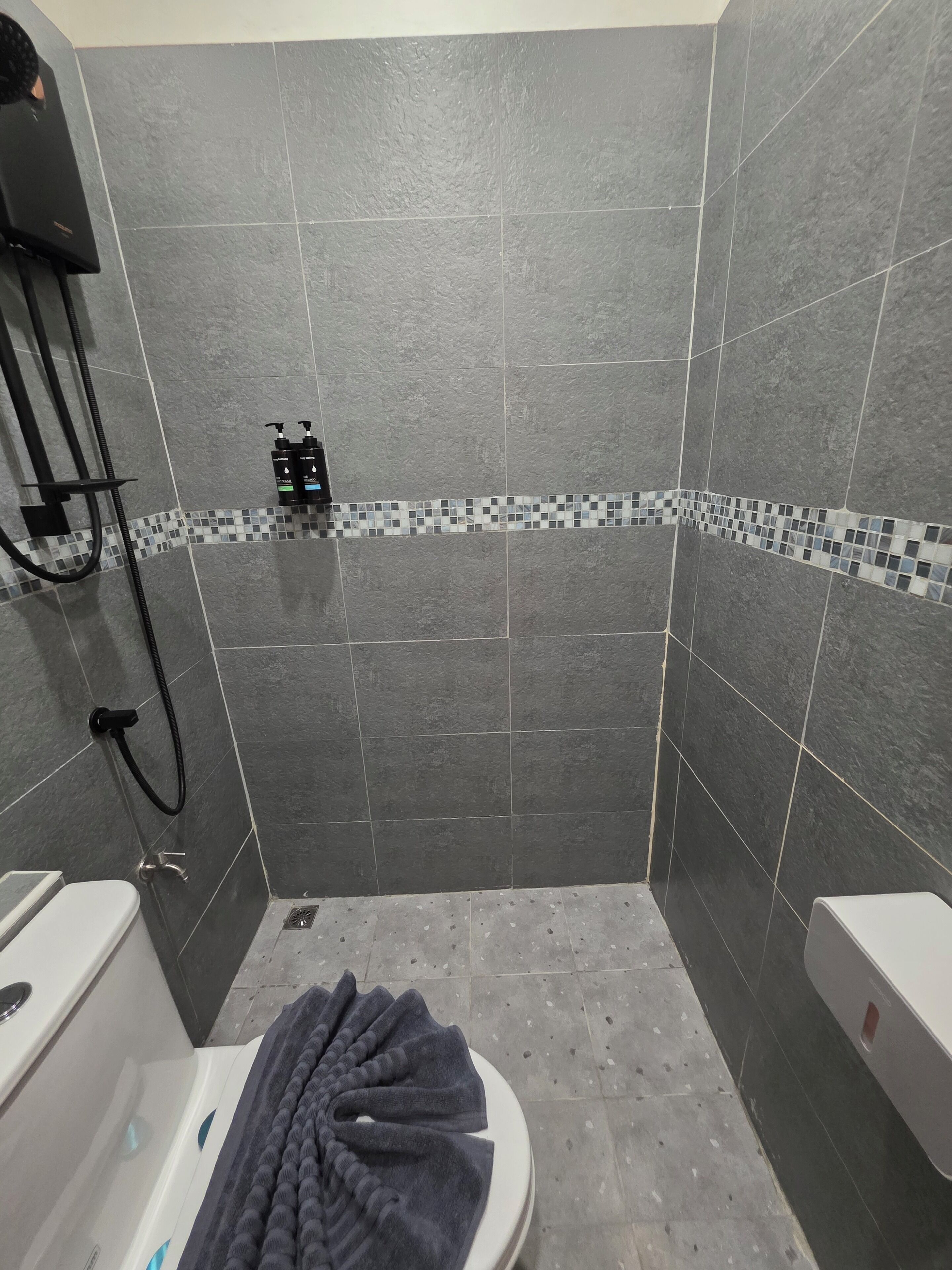 A bathroom with a shower, a toilet, and a sink.