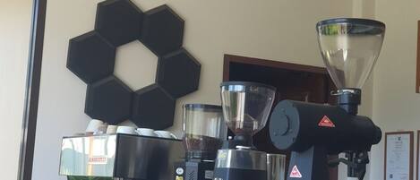 A coffee machine, a hexagonal wall decoration, and a window with blinds.