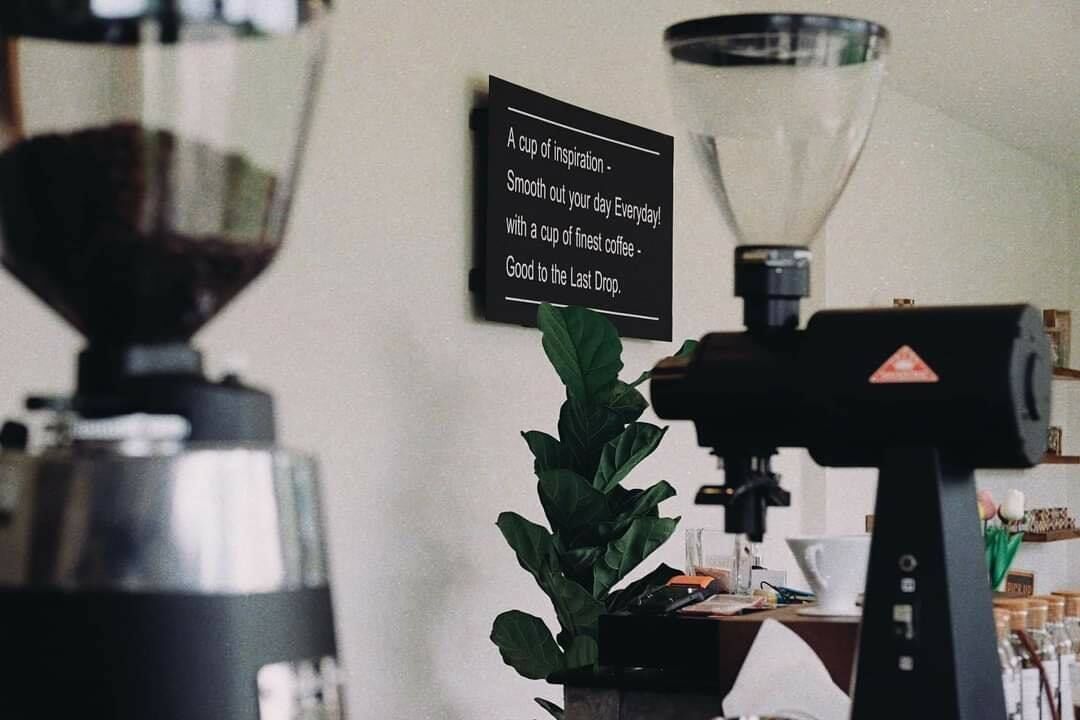 A coffee machine and a sign with a motivational quote.