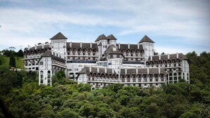 A large, multi-story hotel with a traditional architectural style, featuring multiple towers and balconies. - Duplex em Castelo Piscina e Lareira (Campos do Jordão)