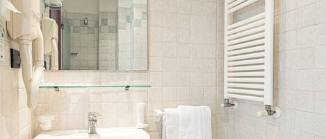 A bathroom with a pedestal sink, a mirror, a towel rack, and a glass shelf.
