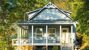 Ein kleines, eingeschossiges Haus mit Veranda, überdachter Eingangszone und kleinem Vorgarten.