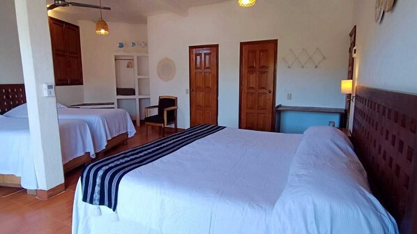 A hotel room with two beds, a wooden headboard, a desk, and a chair.