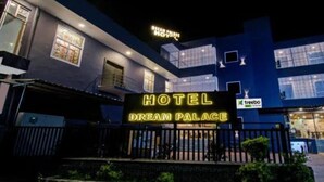 Ett hotell som heter ”Dream Palace”, med en tydlig skylt, en modern arkitektonisk design och en väl synlig entré.
