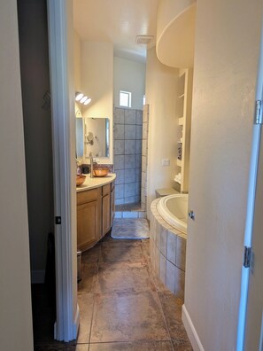 Une petite salle de bain comprenant un meuble-lavabo, une baignoire et un espace douche.