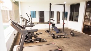 Un gimnasio con cintas de correr, una banca de pesas y una jaula para sentadillas.