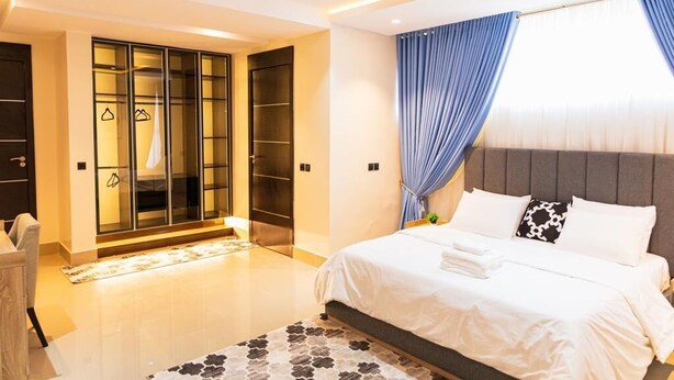 Un dormitorio moderno con una cama grande, un armario y una zona de estar.