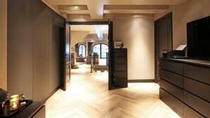 A modern interior with a herringbone floor, a flat-screen TV, and a staircase leading to a loft area. - Luxury, Newly Remodeled Apartment in 16th Century Warehouse, with 10 meter Boat. (amsterdam)