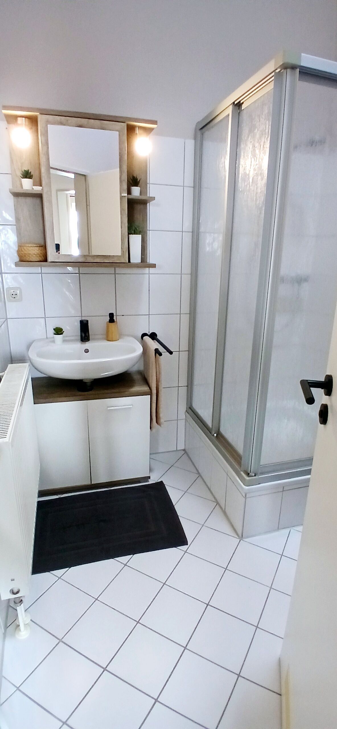 Ein Badezimmer mit Waschbecken, Spiegel und Dusche.