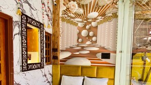 A modern living room with a marble-patterned wall, a ceiling fan, a sofa, a coffee table, and a decorative mural.