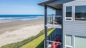 A modern building with a balcony overlooking a beach. - Experience Nature's Spectacle from the Front Row! (Newport)
