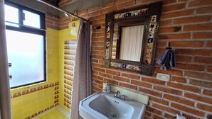 Une salle de bain avec un lavabo, un miroir et une fenêtre.