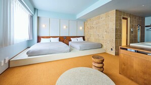 Una habitación de hotel con dos camas, una mesita de noche de madera, un tapete redondo y una pared con azulejos.