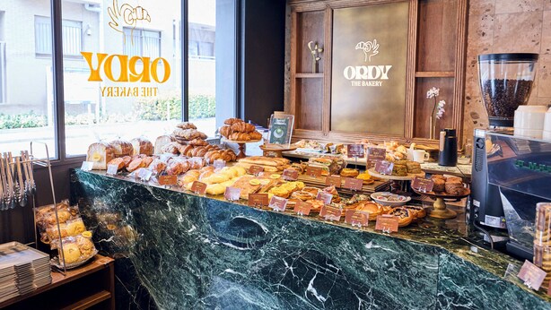 Un mostrador de panadería con una variedad de productos horneados y una máquina de café.