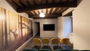 A hallway with a forest mural, a fireplace, and several chairs.