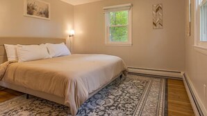 A bedroom with a bed, a ceiling fan, a window, and a rug. - 3-bedroom Cozy Home in Ellsworth with AC, WiFi (Ellsworth)