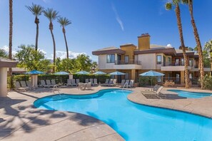 Relax by the pool surrounded by lounge chairs and umbrellas.