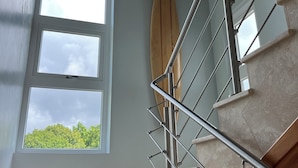 Eine Treppe mit einem Holzgeländer und einem Surfbrett, das an der Wand lehnt.