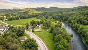 A rural landscape with a winding road, houses, and a river.