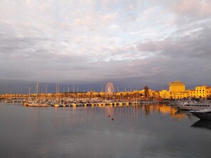A marina with numerous boats, a Ferris wheel, and buildings in the background. - ALGHERO HISTORICAL CENTER STUDIO "CASA AZUL" (Alghero)