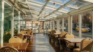 Ein Restaurant mit Glasdecke, Holztischen und -stühlen.