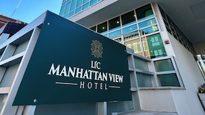 Das LIC Manhattan View Hotel mit moderner Glasfassade und auffälligem Schriftzug.