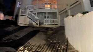Un edificio de varios pisos con balcones y una escalera que lleva a la entrada.